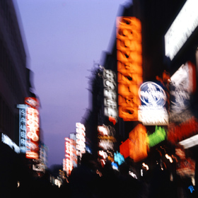 Leuchtreklame in der Abenddämmarung einer Stadt in Deutschland.